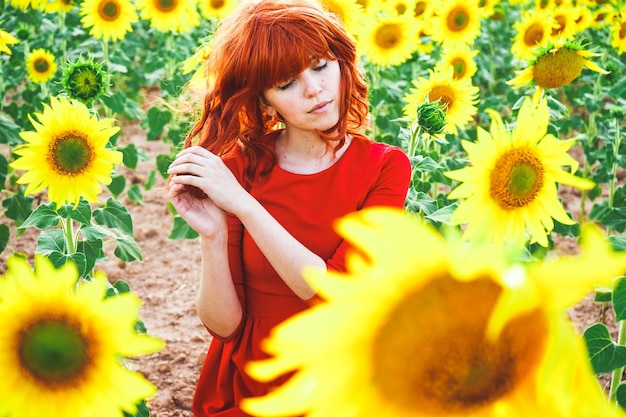 Smiling young woman with yellow flowers in field