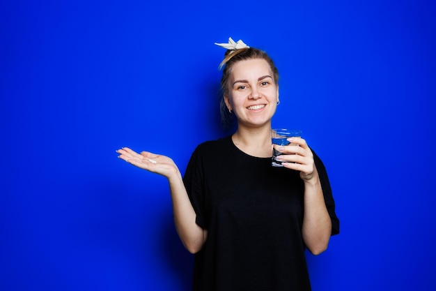 Smiling young woman without makeup in black tshirt drinking vitamins for health mature woman natural beauty concept morning glass of water immune care vitamin complex for women selective focus