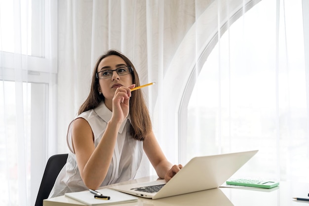 Smiling and young woman working in office with documents