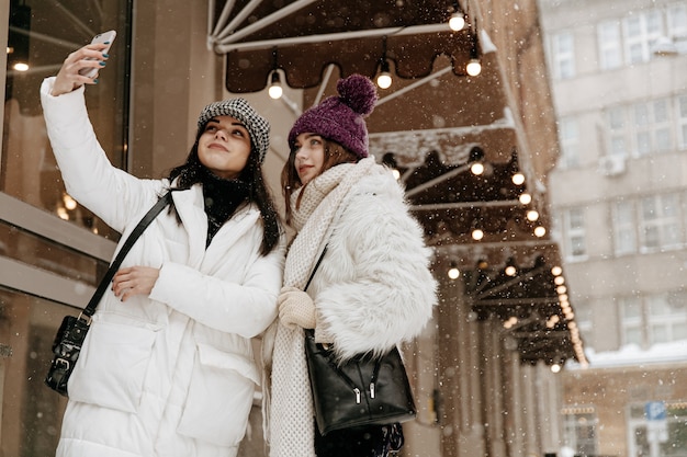 Smiling young women wearing warm winter clothing chatting