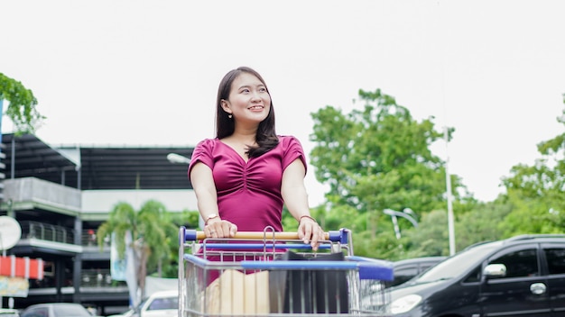 Smilling aziatische vrouw winkelen met trolley