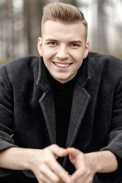 smilling close-up fashion male model in coat, art portrait of man