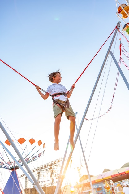 Foto smilling opgewonden jongen springen op een trampoline met verzekering.