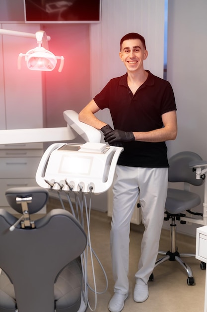 Улыбающийся врач-стоматолог в современной больнице. Портрет профессионального дантиста.