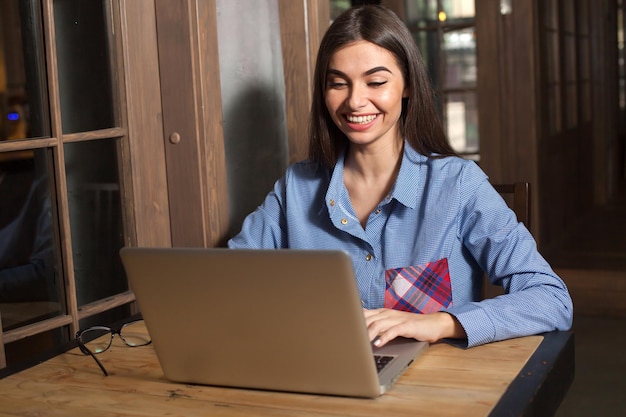 Smilling woman is working with laptop