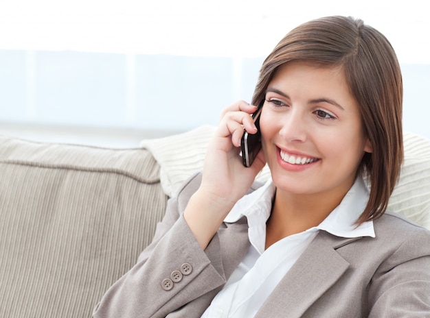 Smilng Businesswoman phoning on her sofa 