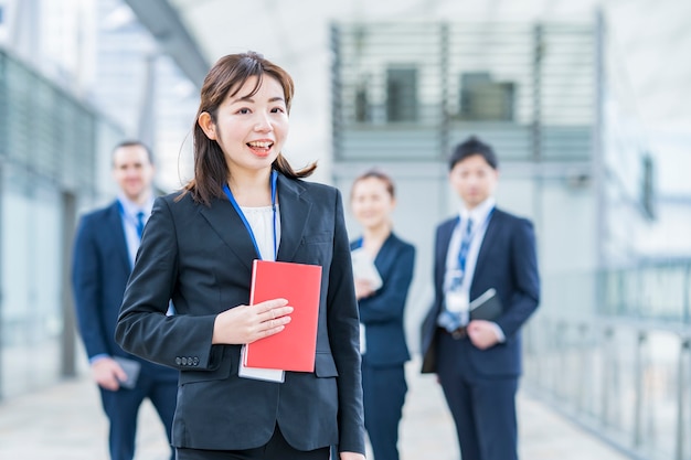 Smily asian business woman standing and her business team