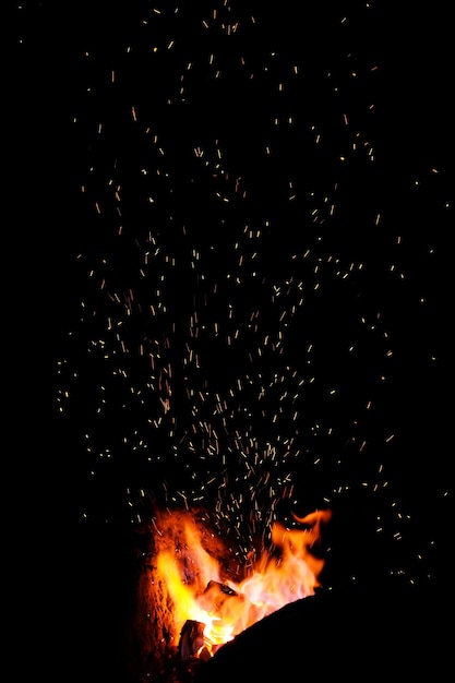 Smithy fire flame tips with sparks closeup on dark background