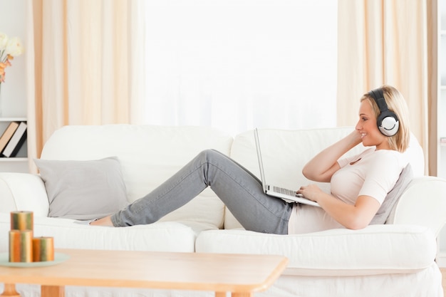 Smling vrouw kijkt naar een film met haar laptop