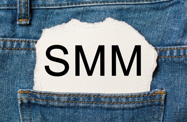 Smm on torn paper background on jeans business and finance concept