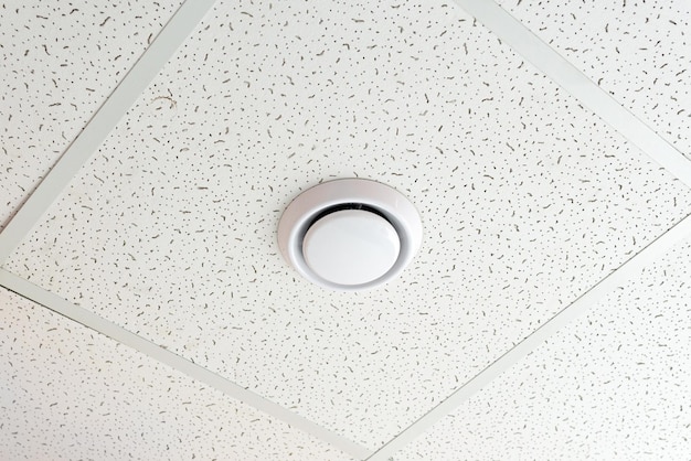 Smoke detector on the ceiling of an office building or a room\
in a residential building