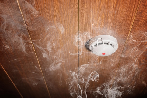 Smoke detector and fire alarm in action background with copy space