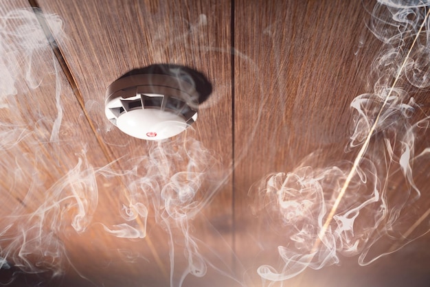 Smoke detector and fire alarm in action background with copy space