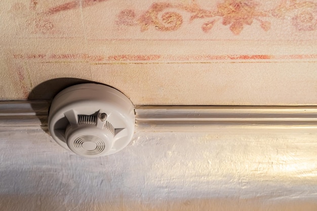 Smoke detector of the fire alarm system on the ceiling of the house or office A smoke detector installed in an old apartment Risk of fire smoke detector on the ceiling