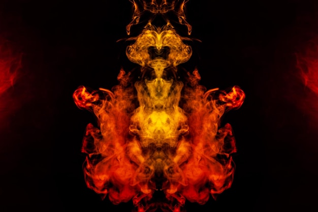 Smoke of different orange and red colors in the form of horror in the shape of the head face and eye with wings on a black isolated background Soul and ghost in mystical symbol