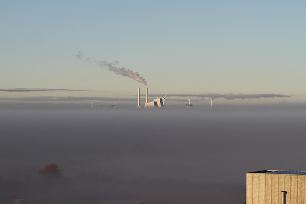 Smoke emitting from chimney against sky