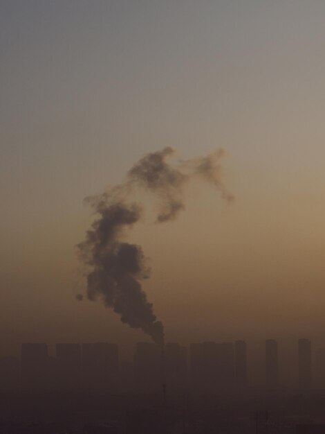 Foto fumo emesso dalla fabbrica contro un cielo limpido