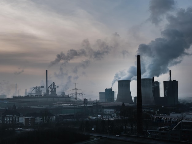 Smoke emitting from factory against sky