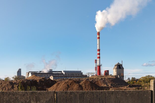 Smoke emitting from factory against sky