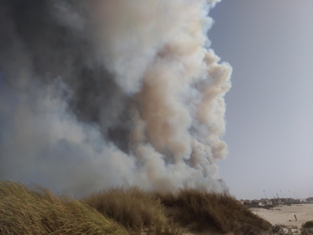 Photo smoke emitting from landscape against sky