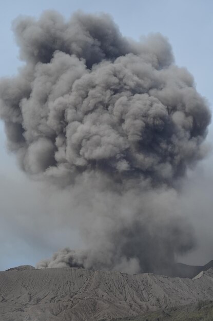 Photo smoke emitting from volcanic mountain against sky