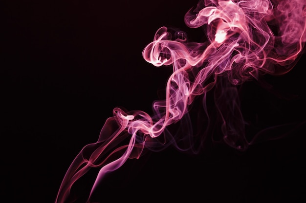 Smoke floating in the air on dark background