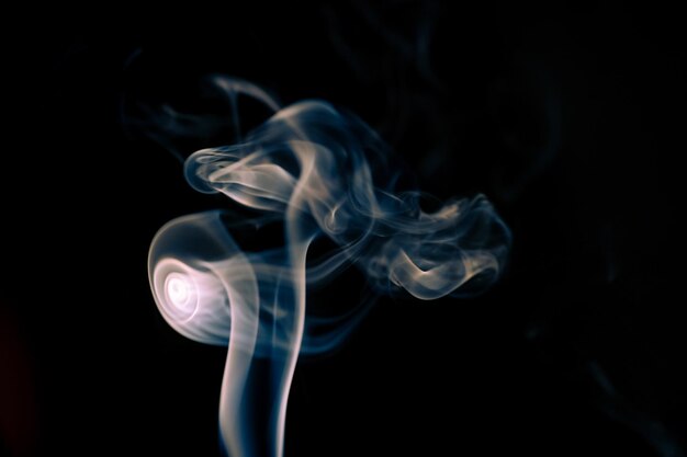 Photo smoke from a candle in a black background