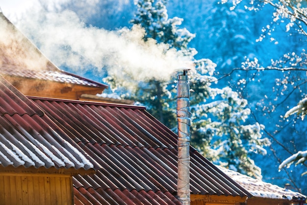 Smoke from the chimney on the roof at sunny day