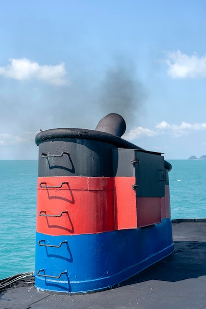 Smoke from ferry boat flue during sea with sunlight sea water and clear sky in background Thailand