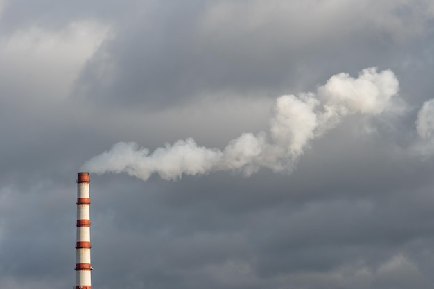 The smoke from the power plant chimney environmental pollution\
nonrenewable energy sources large chimney against a background of\
grey clouds environmental disaster