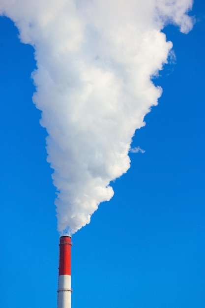 Smoke is coming from the pipes against the blue sky