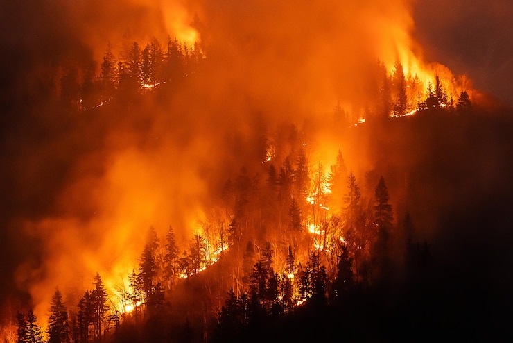 Photo smoke rises after a wildfire over a mountain area threatening health and biodiversity aerial view
