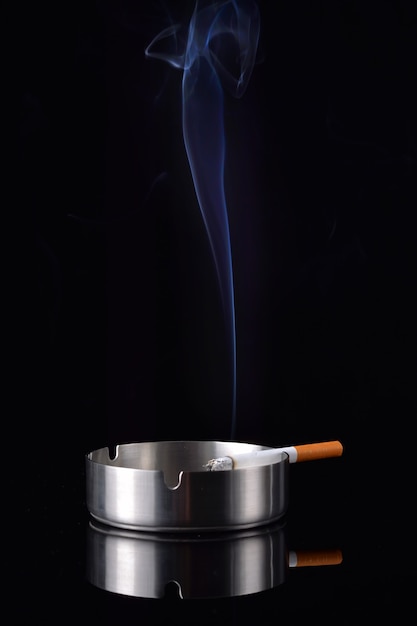 Smoke rising from a cigarette in an ashtray