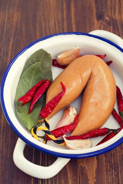 Smoke sausage on white dish on wooden surface