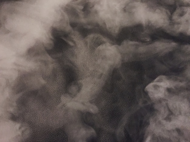 Photo smoke screen on a black leather background which creates a slight grainy look and feel.