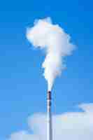 Photo a smoke stack that is smoking from a tall stack