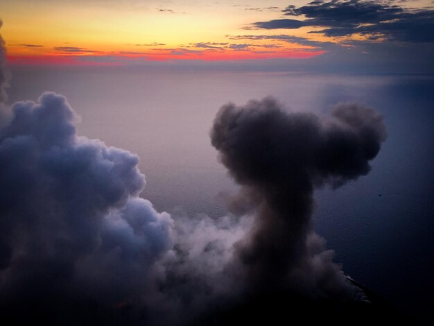 사진 해가 지는 동안 하늘을 향해 연기가 쌓인다