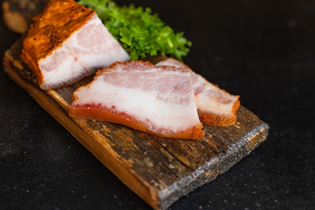 Smoked bacon with spices on a wooden board