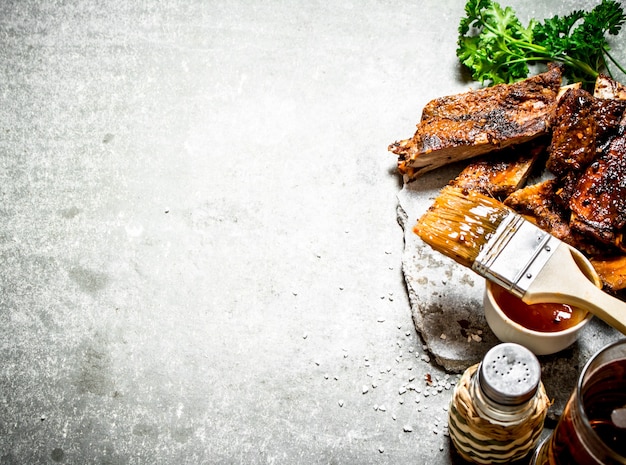 Smoked barbecue ribs with beer and herbs on concrete.