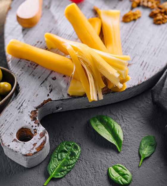 Smoked braided cheese on wooden board