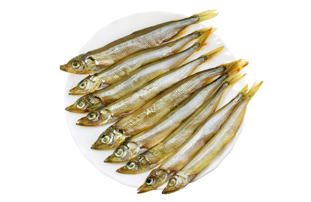 Smoked capelin on a white plate close-up isolated