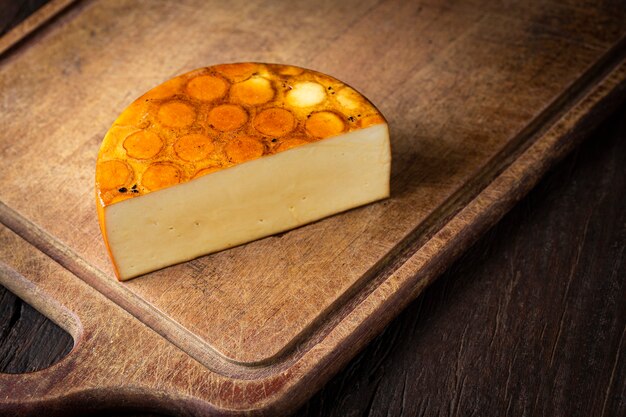 Копченый сыр Кусок копченого сыра на столе