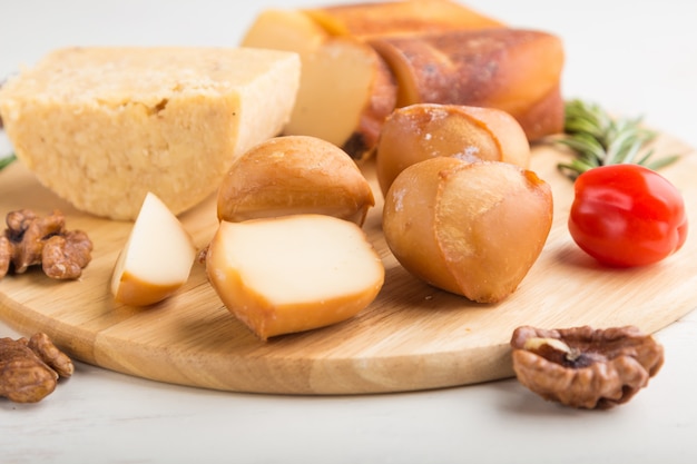 Smoked cheese and various types of cheese with rosemary and tomatoes