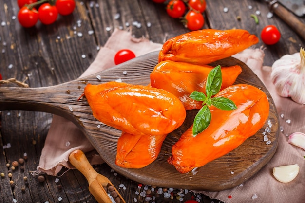 smoked chicken breasts, spices, vegetables on a kitchen cutting board, dark and moody, clouseup on a