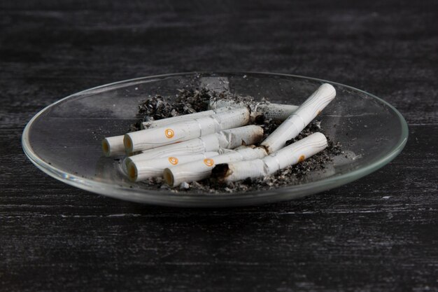 Photo smoked cigarettes in a clear ashtray