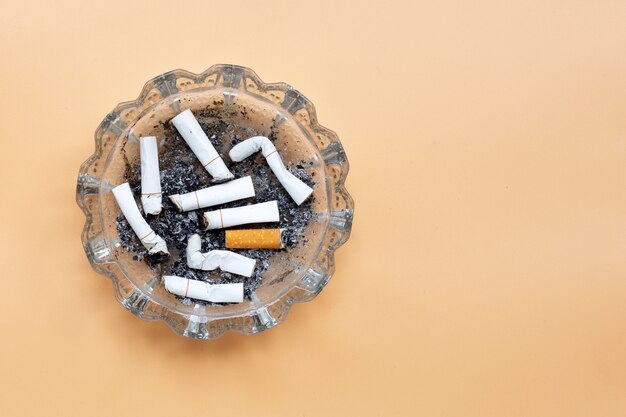 Smoked cigarettes on cream color background.