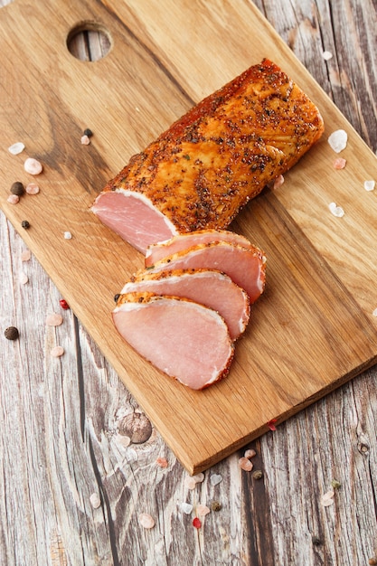 Smoked dried ham on a chopping board.