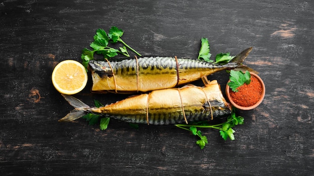 Smoked fish On a black wooden background Top view Free space for your text