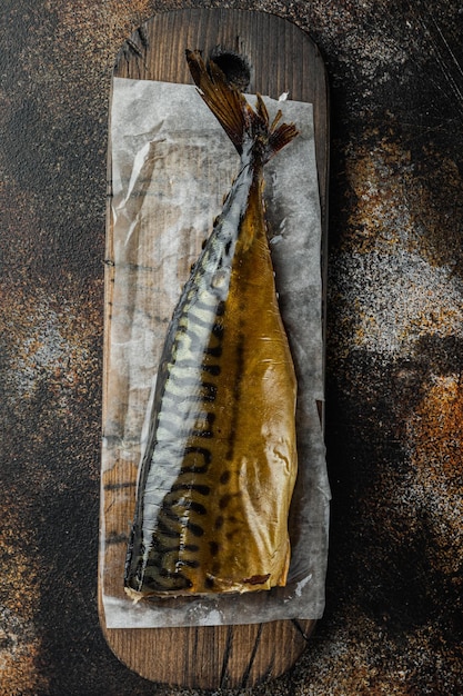 Smoked fish mackerel, on old dark rustic background, top view flat lay