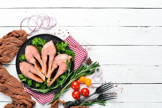 Smoked fish steaks on a black plate Red salmon fish Top view Free copy space